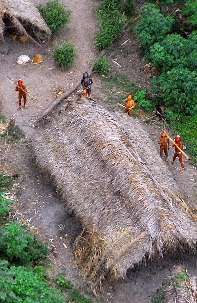 A 2008 photo showing members of a recently discovered indigenous tribe, with their bodies painted in bright red staring at the aircraft from which the pictures were taken, in the Amazon region in the Brazilian-Peruvian border. Picture: Brazilian Indian Protection Foundation