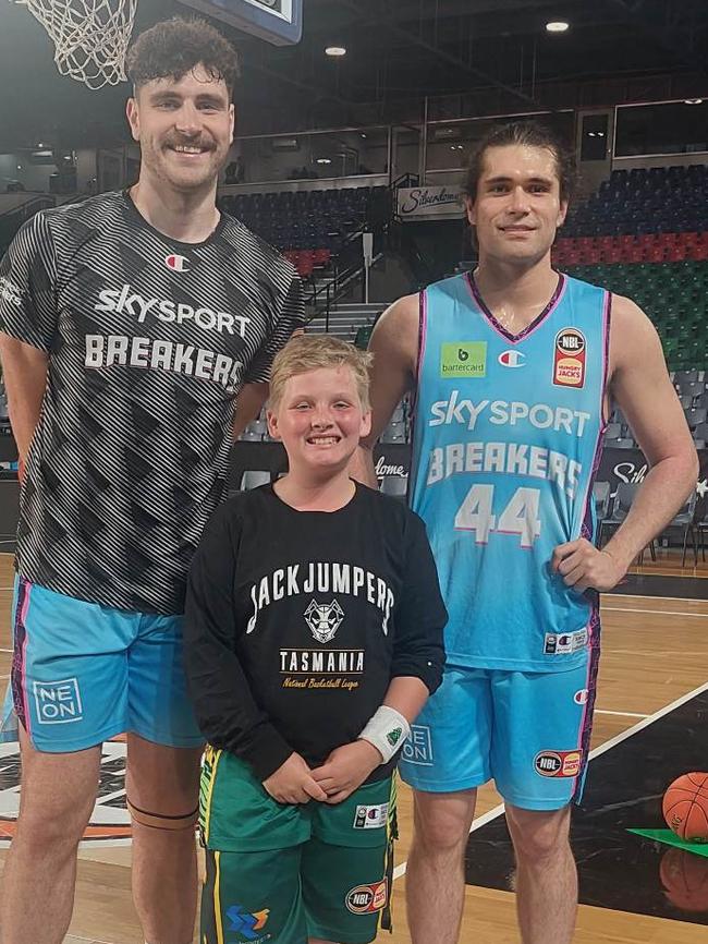 Tassie youngster Zachary Kooistra, 10, with New Zealand Breakers NBL players Sam Timmins (left) and Isaac Davidson, who the youngster apologised to after bad crowd behaviour at the JackJumpers clash on November 18, 2022.