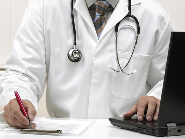 Doctor writing patient notes on a medical examination form or prescription