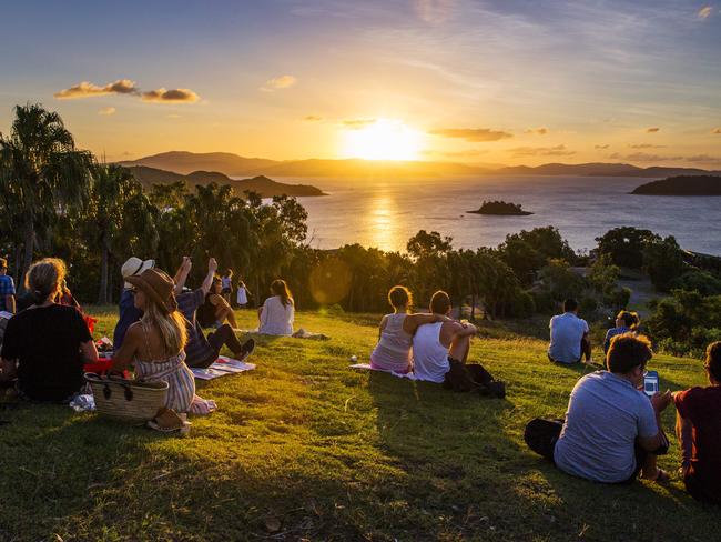 Tourists gather on One Tree Hill to watch the sunset from Hamilton Island. Picture: Lachie Millard