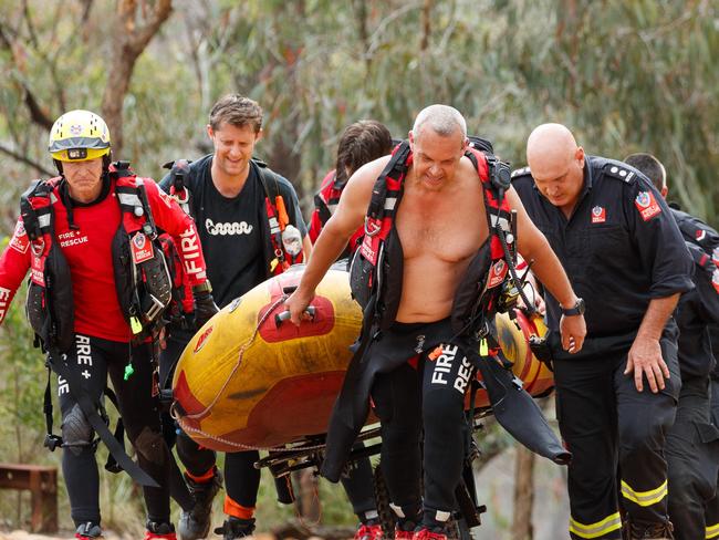 DAILY TELEGRAPH. Firefighters push an inflatable boat back up the steep climb from Nortons Basin in Mulgoa where a person has reportedly drowned. Saturday 16/11/2024. Picture by Max Mason-Hubers