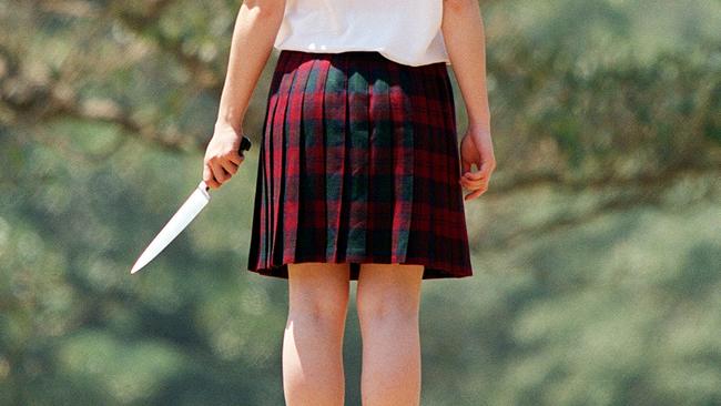 NOVEMBER 8, 2002: Rear view of model posing as schoolgirl with knife 08/11/02, to illustrate the girl who took part in the stabbing murder of Stephen Tonkiss in 2001. pic Bob Barker. NSW / Crime People / Situation