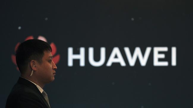 In this Jan. 9, 2019, photo, a security guard stands near the Huawei company logo during a new product launching event in Beijing. The Chinese Foreign Ministry said late Friday, Jan. 11, 2019, it is "closely following the detention of Huawei employee Wang Weijing" on charges of allegedly spying for China, and has asked Poland to "handle the case lawfully, fairly, properly and to effectively guarantee the legitimate rights of the person, his safety and his humanitarian treatment," according to state broadcaster CCTV. (AP Photo/Andy Wong)