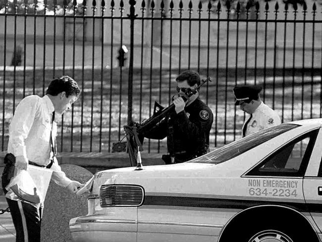 Police officers carry the gun to a car after the shooting.