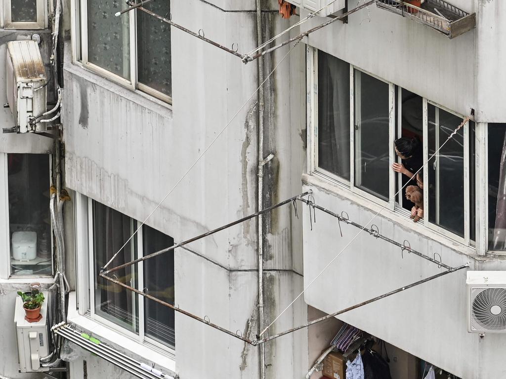 People look out the window of a residential building during coronavirus lockdown in the Jing'an district in Shanghai. Picture: AFP