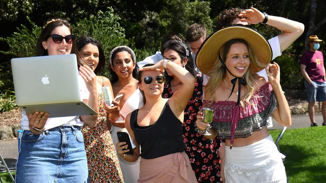 Punters watch the spectator-free Melbourne Cup horse race on a laptop as they picnic in a park overlooking the Flemington Racecourse in Melbourne, Picture: William West/AFP