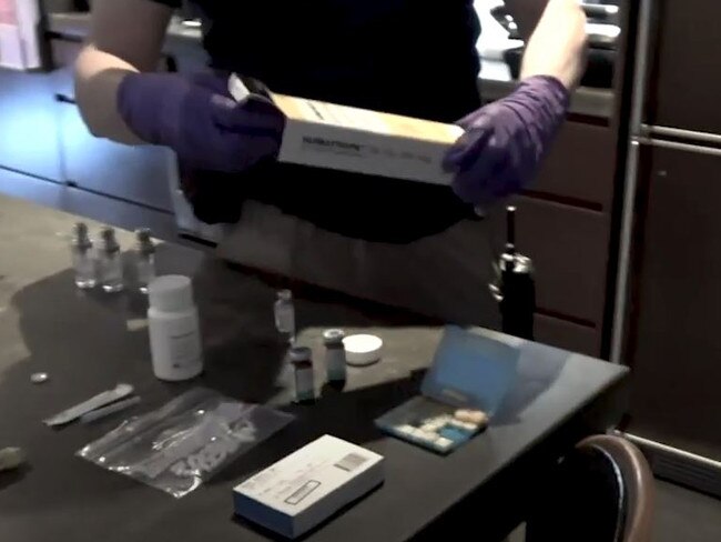 An officer inspecting one of the packages removed from the fridge, which is later identified as female fertility drugs.