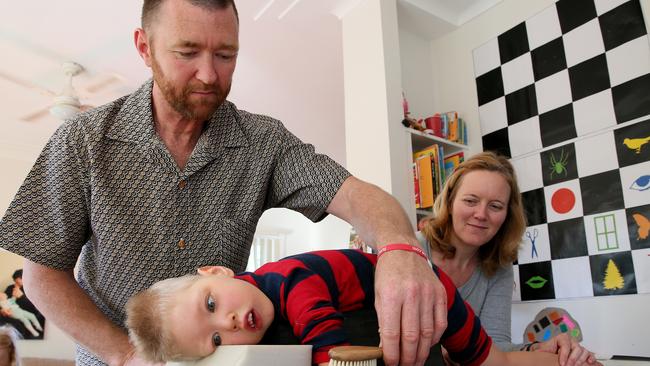 David and Ina Mills give son Roki, 3, physical therapy at their Newport home. Picture: Troy Snook