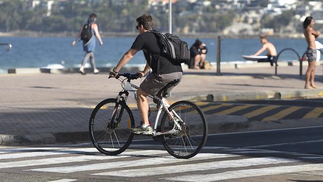 Cyclists without helmets and riding across pedestrian crossings in Manly