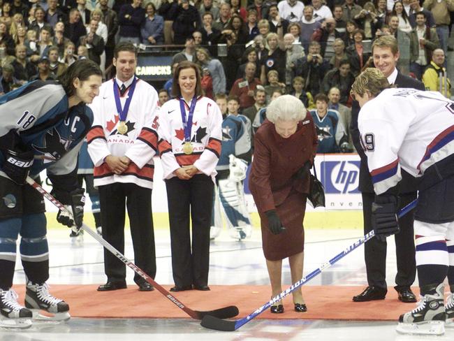 Queen Elizabeth II drops the puck during the ceremonial face-off between Markus Naslund of the Vancouver Canucks and Mike Ricci of the San Jose Sharks in 2002.