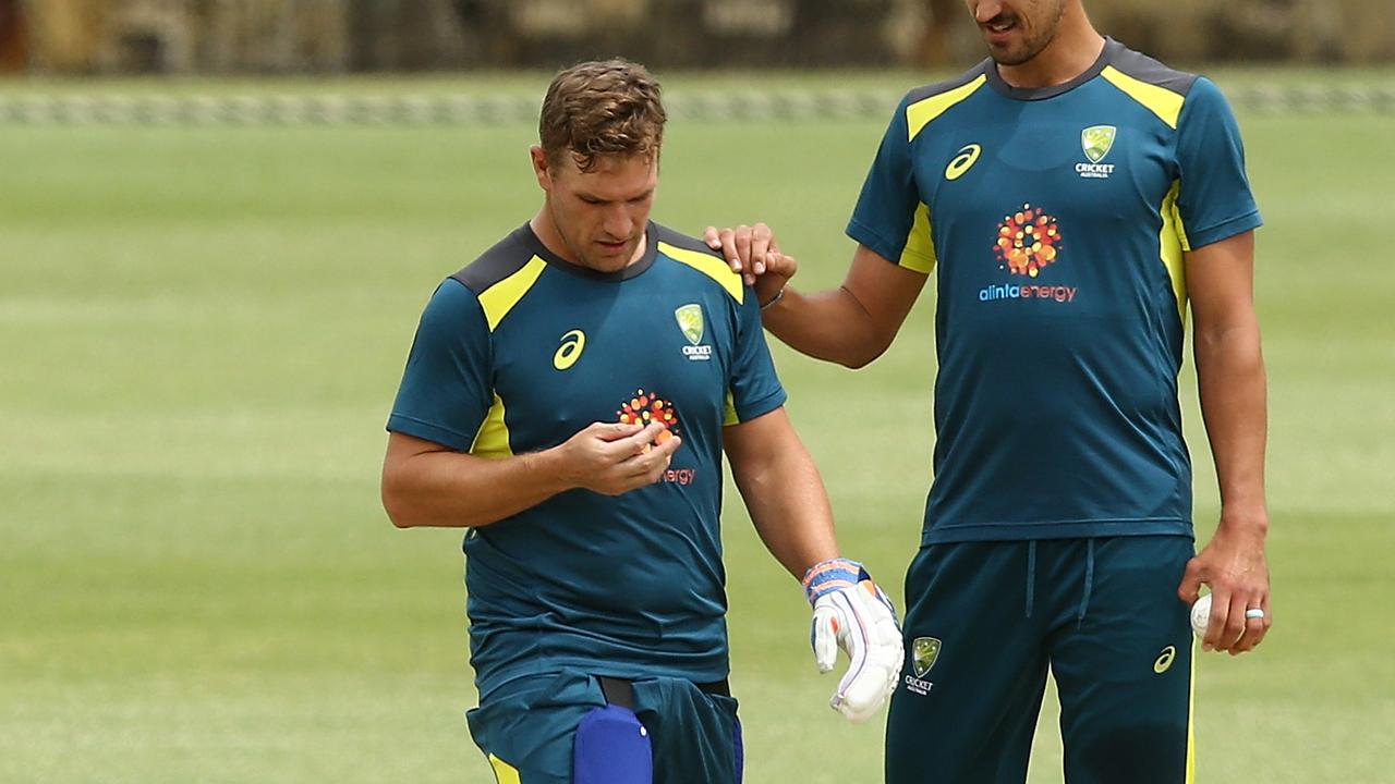 Aaron Finch of Australia inspects his finger after being struck by a delivery off Mitchell Starc during the Australia training session in Perth.