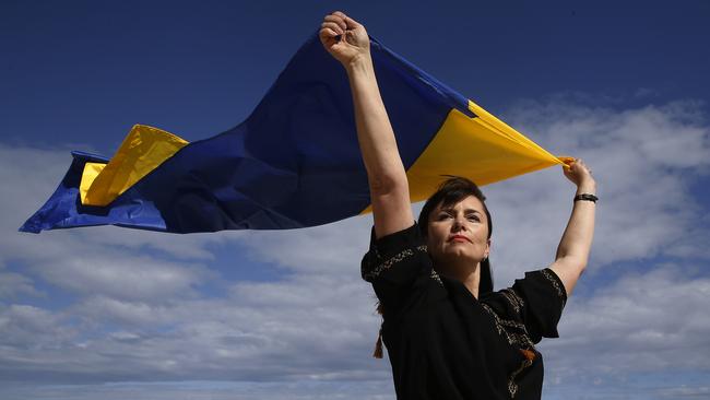 Natalia Borodina flying Ukrainian flag on Bronte Beach where she helps facilitate a learn to swim program out of Bronte Surf Club. Picture: John Appleyard