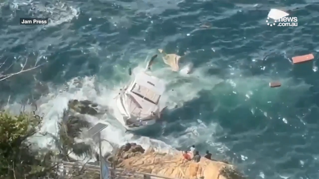 Yacht crashes into rocks and sinks