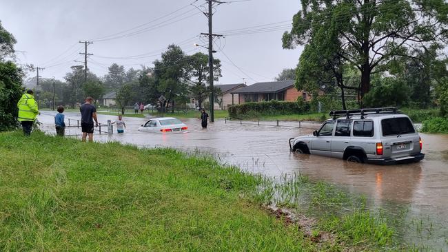 A four-wheel drive tows a sedan which became stranded in floodwater on Bray Street, Coffs Harbour, on Monday, February 28. Picture: Steve Zaal