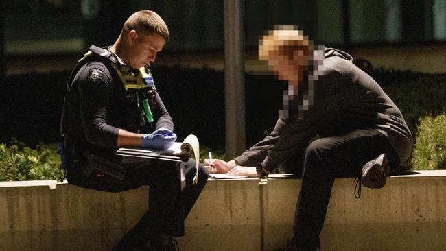 Police interview a witness at the scene of the stabbing. Picture: David Geraghty