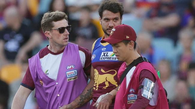 BRISBANE, AUSTRALIA - AUGUST 07: Callum Ah Chee of the Lions is assisted from the ground during the 2022 AFL Round 21 match between the Brisbane Lions and the Carlton Blues at The Gabba on August 7, 2022 in Brisbane, Australia. (Photo by Russell Freeman/AFL Photos via Getty Images)