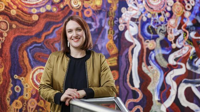 2020 Adelaide Biennial curator Leigh Robb in front of the Ken Family's triptych painting "Kangkura-KangkuraKu Tjukurpa — A Sister’s Story". Picture: Saul Steed