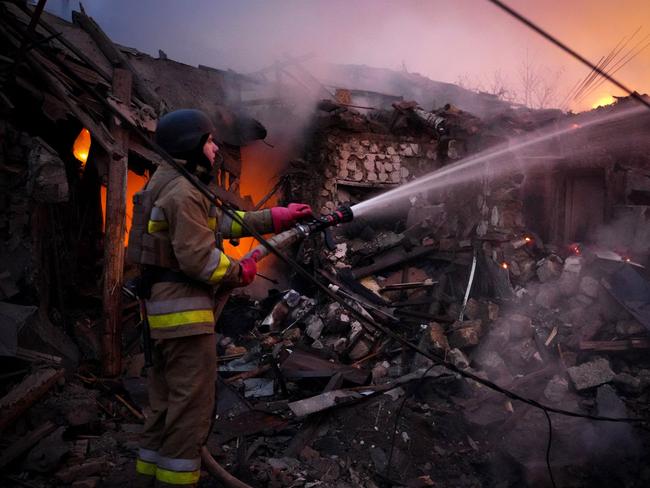 A Ukrainian rescuer works to extinguish a fire in a building following a drone attack in Mykolaiv. Picture: AFP