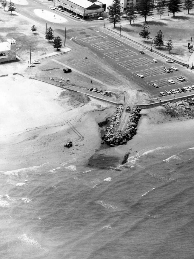 An aerial shot of work on the breakwater at the entrance to the Patawalonga boat haven. The Glenelg carpark is in the background with the end of Anzac Highway and Colley Reserve at top right — 1964.