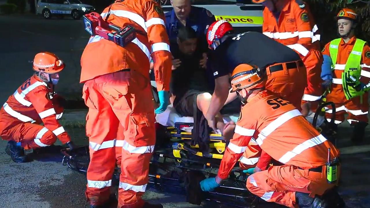 A man is treated by paramedics after a crash that happened in an exit lane from the Pacific Highway at Moonee Beach on March 9, 2022.