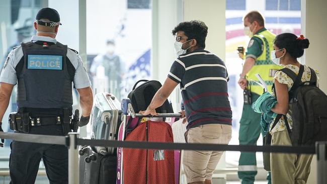 Passengers being escorted through Adelaide Airport on Monday, on their way to quarantine in the city. Picture: Mike Burton/AAP