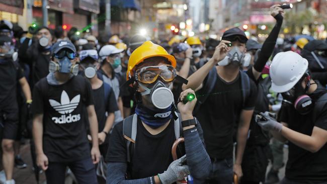 Protesters use laser pointers against policemen during the anti-extradition bill protest in Hong Kong yesterday. Picture: AP