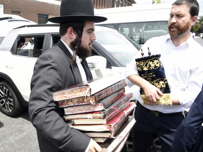 Members of the Jewish community remove religious material from the Adass Synagogue after the fire. Picture: Andrew Henshaw