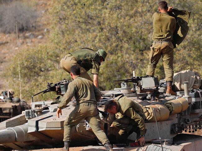 Israeli soldiers take part in a military drill aboard a Merkava tank near the border with Lebanon in the upper Galilee region of northern Israel. Picture: AFP