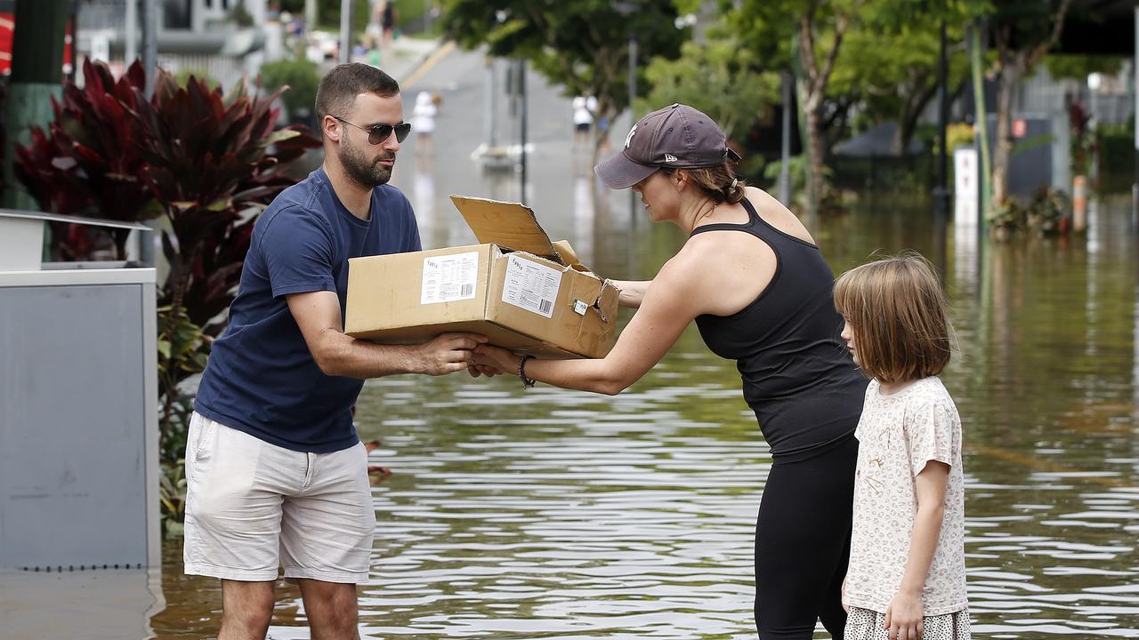 People pictured moving products out of shops in Brisbane during the floods in February. Picture: Josh Woning