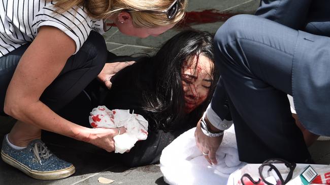 Erin tended to by others on the street after she was struck by the car on Bourke St. Picture: Tony Gough