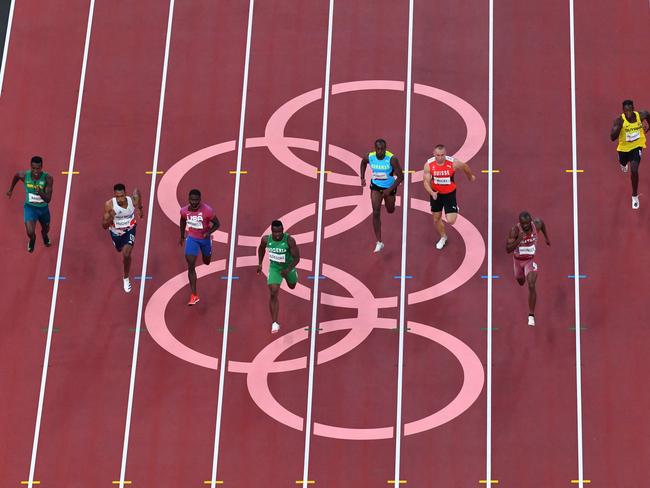 From L: Brazil's Felipe Bardi Dos Santos, Britain's Zharnel Hughes, USA's Trayvon Bromell, Nigeria's Enoch Adegoke, Bahamas's Samson Colebrooke, Switzerland's Silvan Wicki, Qatar's Femi Ogunode, Guyana's Emanuel Archibald and Refugee Olympic Team's Dorian Keletela compete in the men's 100m heats during the Tokyo 2020 Olympic Games at the Olympic Stadium in Tokyo on July 31, 2021. (Photo by Antonin THUILLIER / AFP)