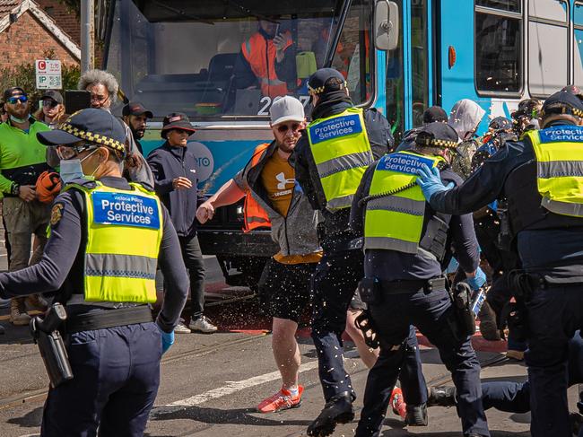 A protester appears to swing his arm back to attack a police officer. Picture: Jason Edwards