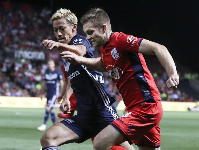 Adelaide United’s Ryan Kitto looks to get past Melbourne Victory’s Keisuke Honda. Picture: Sarah Reed 