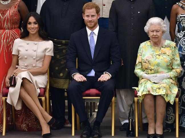 FILE - In this Tuesday, June 26, 2018 file photo, Britain's Queen Elizabeth, Prince Harry and Meghan, Duchess of Sussex pose for a group photo at the Queen's Young Leaders Awards Ceremony at Buckingham Palace in London. As part of a surprise announcement distancing themselves from the British royal family, Prince Harry and his wife Meghan declared they will â€œwork to become financially independentâ€ _ a move that has not been clearly spelled out and could be fraught with obstacles.(John Stillwell/Pool Photo via AP, File)