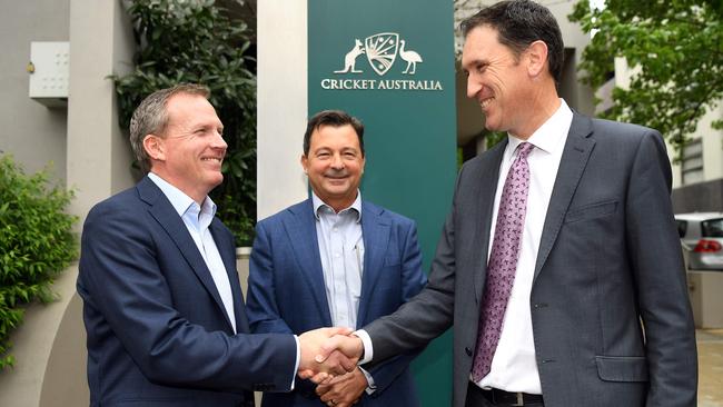 CEO Kevin Roberts (L) shakes hands with outgoing CEO James Sutherland (R) as dumped chairman David Peever looks on. Picture: AFP