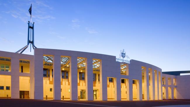 Australian Parliament House illuminated at twilight.