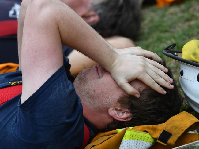 Fire fighters are seen at Kingscote oval after fighting fires through the night, on Kangaroo Island, southwest of Adelaide, Friday, January 10, 2020. CFS volunteers along with over 100 Army Reservists and self-sustainment supplies, are on Kangaroo Island as part of Operation Bushfire Assist at the request of the South Australian Government. (AAP Image/David Mariuz) NO ARCHIVING