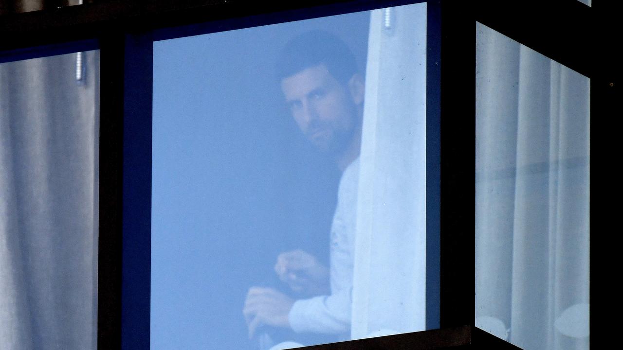 Tennis superstar Novak Djokovic has been seen peeping out of the window of his quarantine hotel in North Adelaide. Picture: NCA NewsWire / Naomi Jellicoe