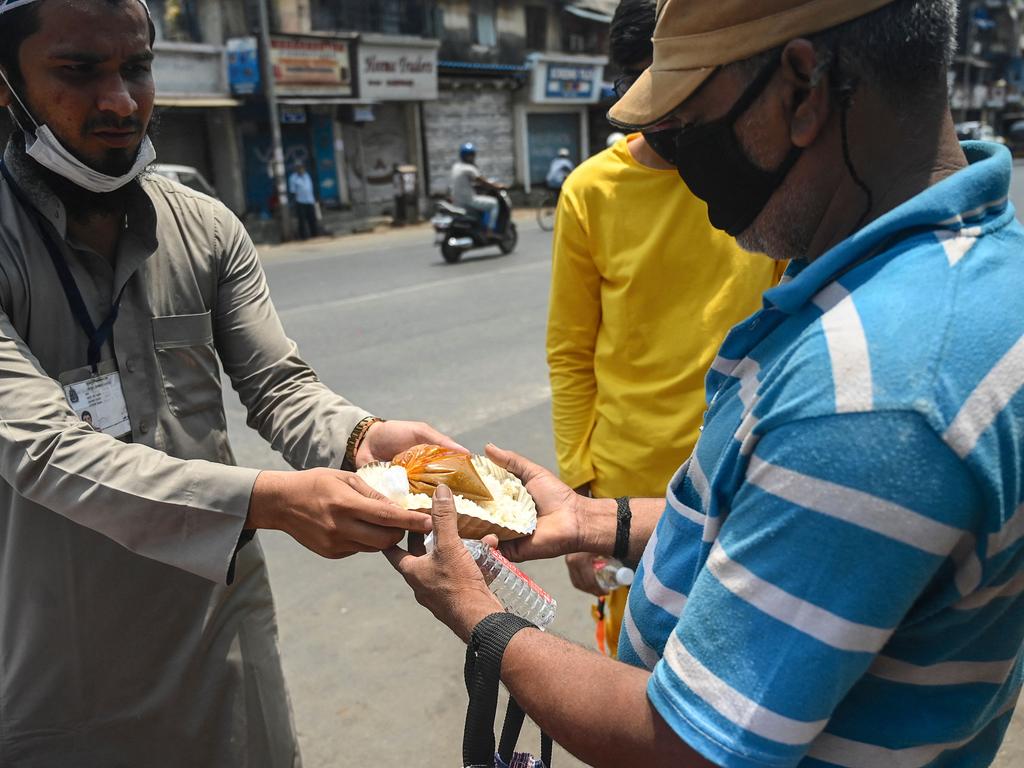 Social workers distribute food outside closed shops in a market during weekend lockdown in Mumbai on April 11, 2021. Picture: Indranil Mukherjee/AFP