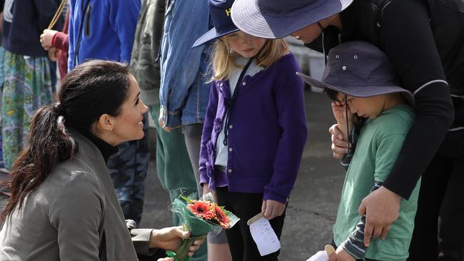 Meeting the royals was all a bit much for little Joe Young, but Meghan talked him through it. Picture: Kirsty Wigglesworth/AP