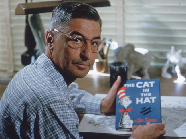 American author and illustrator Dr Seuss (Theodor Seuss Geisel, 1904 - 1991) sits at his drafting table in his home office with a copy of his book, 'The Cat in the Hat', La Jolla, California, April 25, 1957.  (Photo by Gene Lester/Getty Images)