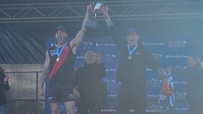 Riddell captain Josh Grabham and coach Arron Bray lift the premiership cup.