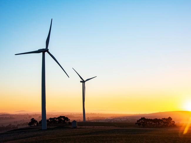 Wind turbine silhouettes with the sun rising over the horizon