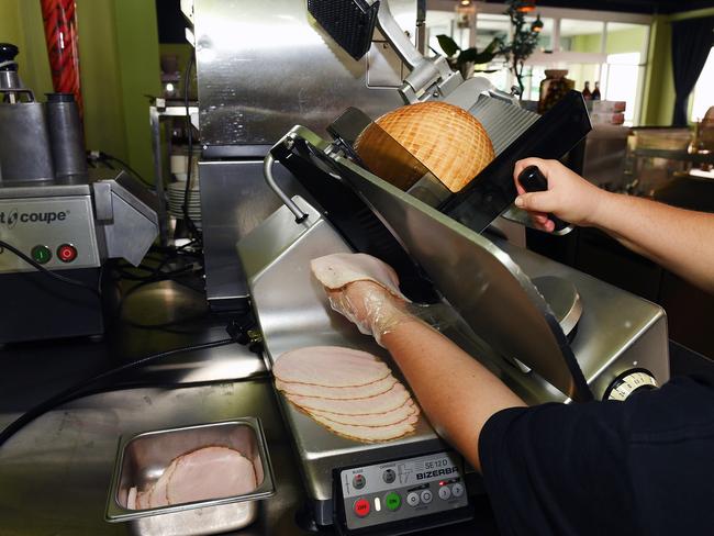 Karyl Pattison slices ham at Papa Christo's Deli/Cafe on Stokes Street. Picture: Shae Beplate.