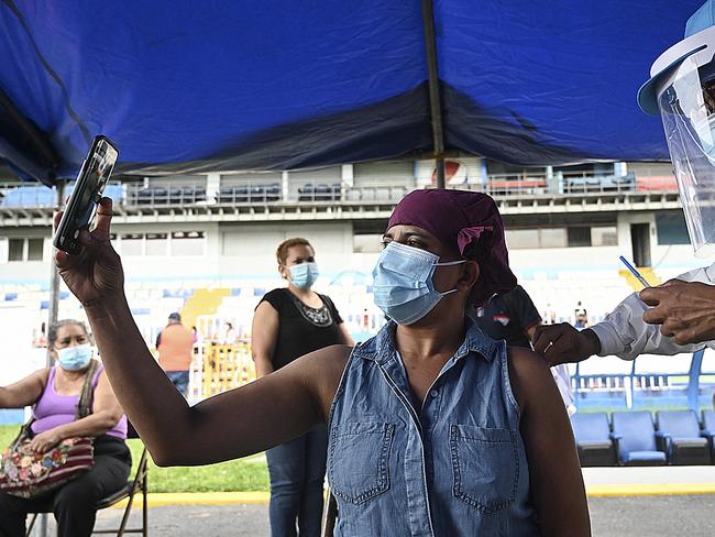 A woman takes a selfie while receiving the first dose of the Moderna vaccine in Honduras. Picture: AFP