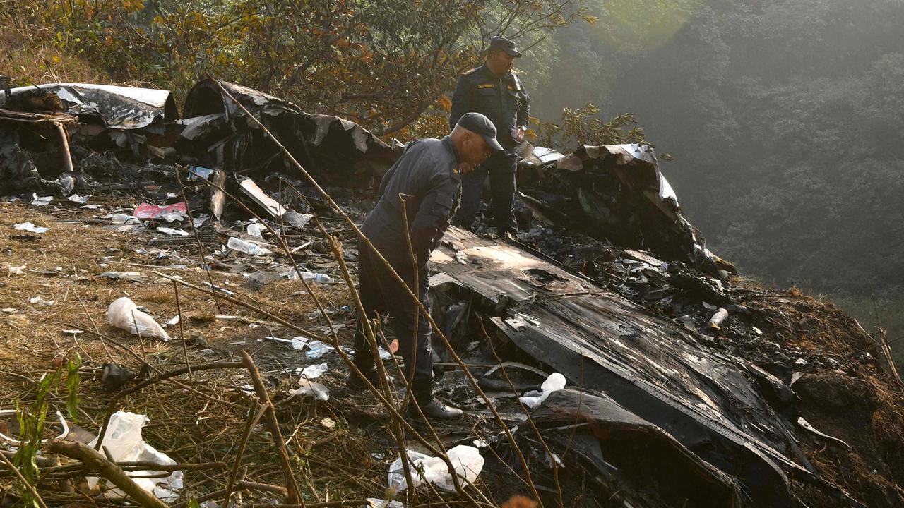 Rescuers inspect the wreckage at the site of a plane crash in Pokhara. Picture: Prakash Mathema/AFP