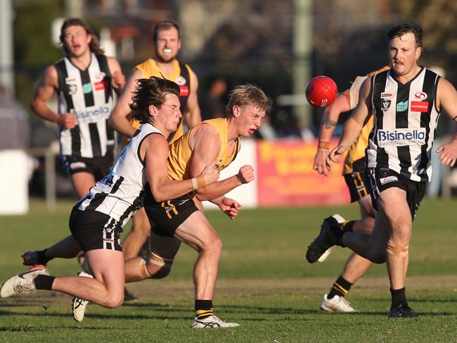 Bannockburn's Austin Mahoney handballs under pressure from North Geelong's Cooper Vaughan. Picture: Alan Barber
