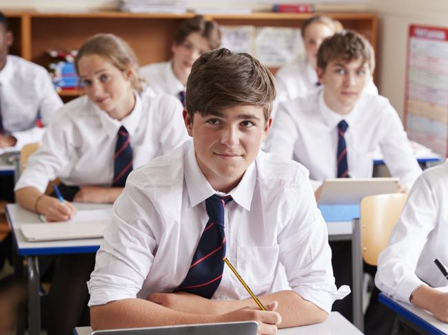 Students Listening To Female Teacher In Classroom