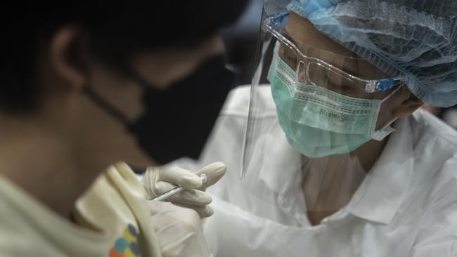 A health worker administers the AstraZeneca Covid-19 coronavirus vaccine to a person at the mass vaccination site inside the Siam Paragon shopping mall in Bangkok, Thailand. Picture: Sirachai Arunrugstichai/Getty Images.