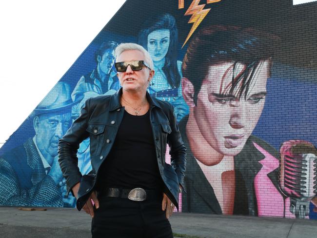 BURLEIGH HEADS GOLD COAST , AUSTRALIA - June 4 2022, Film Director Baz Luhrmann poses for a photo in front of the giant Elvis Presley TCB mural at Burleigh HeadsPicture Scott Powick Newscorp.